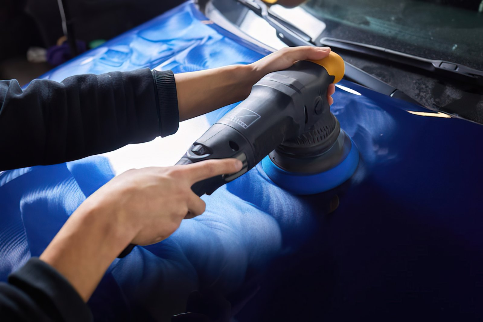 Hand-guided orbital polisher correcting paintwork